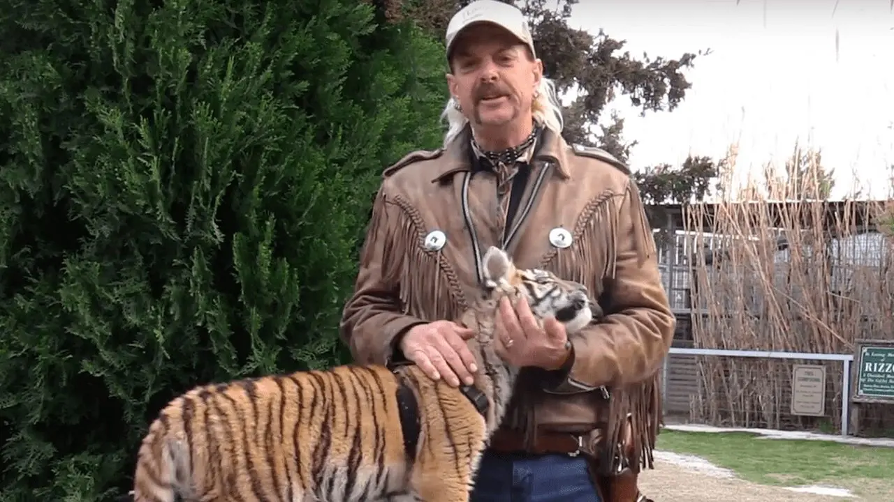 Joe Exotic on camera at his zoo — lights, mic, and tigers